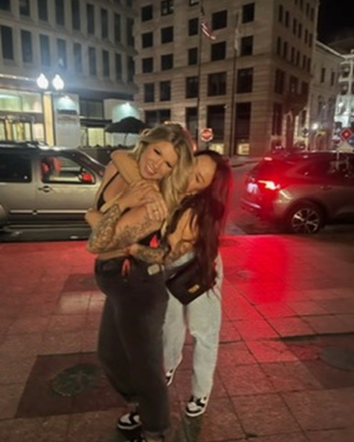 The KYELLA founders hugging on a city street at night