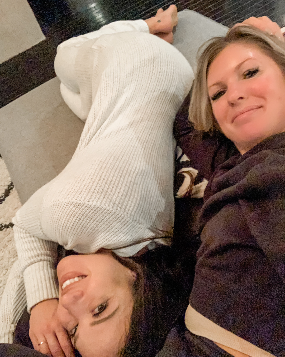 The KYELLA founders lying together and smiling