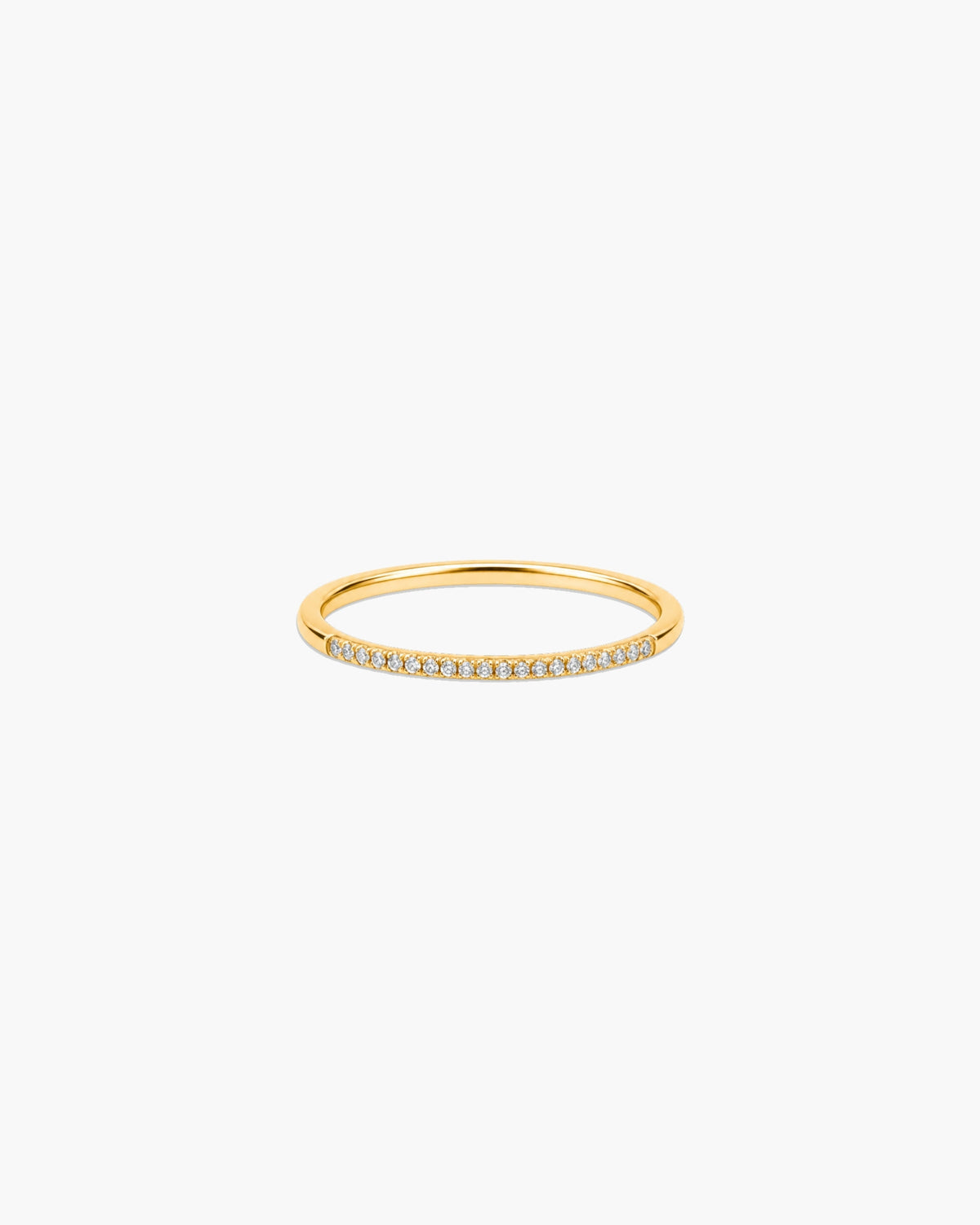 Slim polished gold-tone Aura stacking ring with a delicate row of clear pavé-style stones.