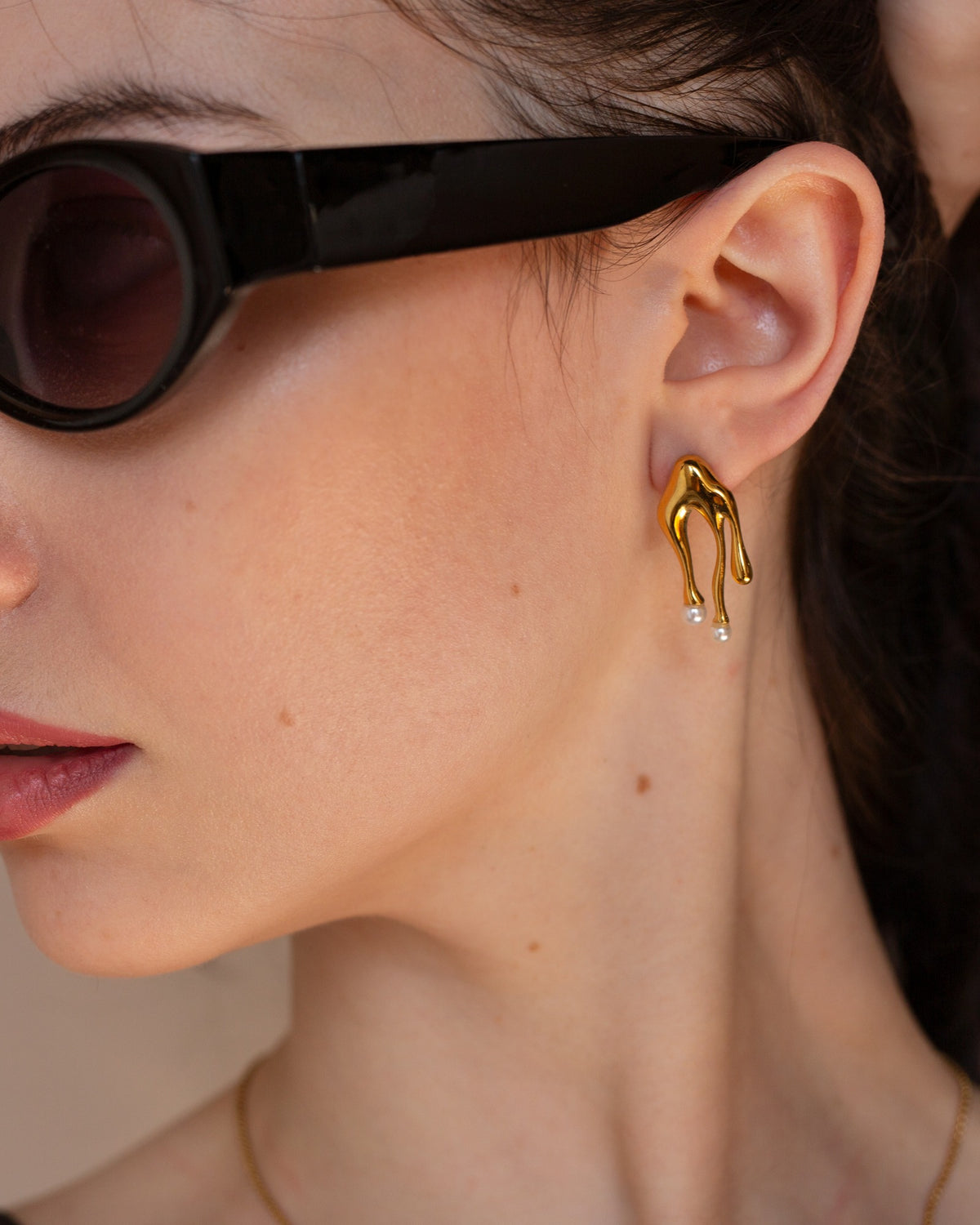 Beatrix sculptural gold earring shown in a tight side portrait.
