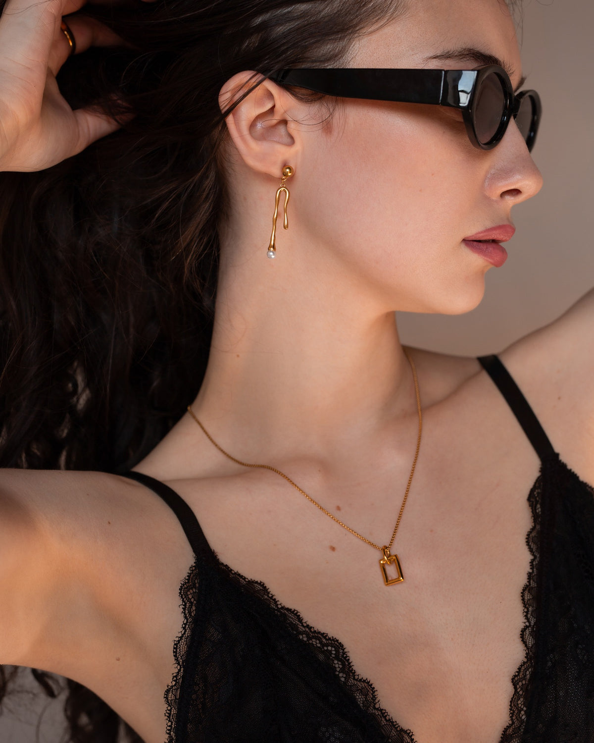 Beatrix asymmetrical pearl drop earring worn in a side profile.