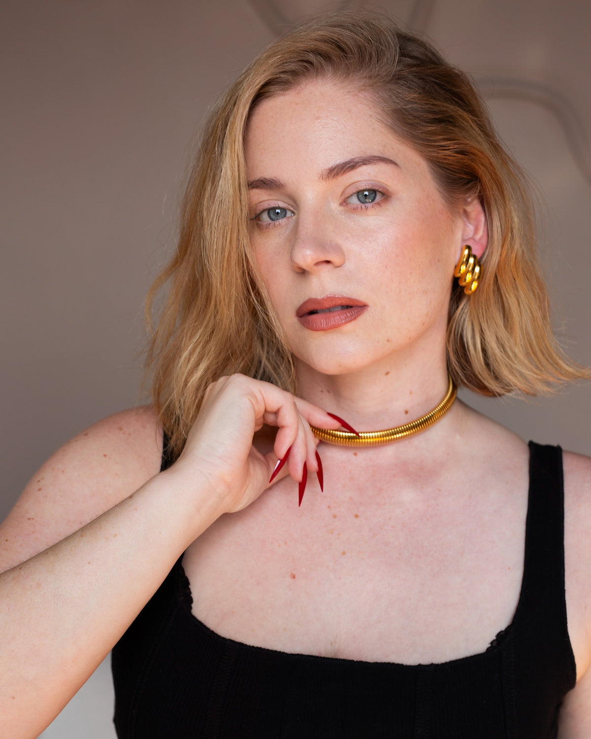 Blanc sculptural gold statement earring styled with a gold choker.