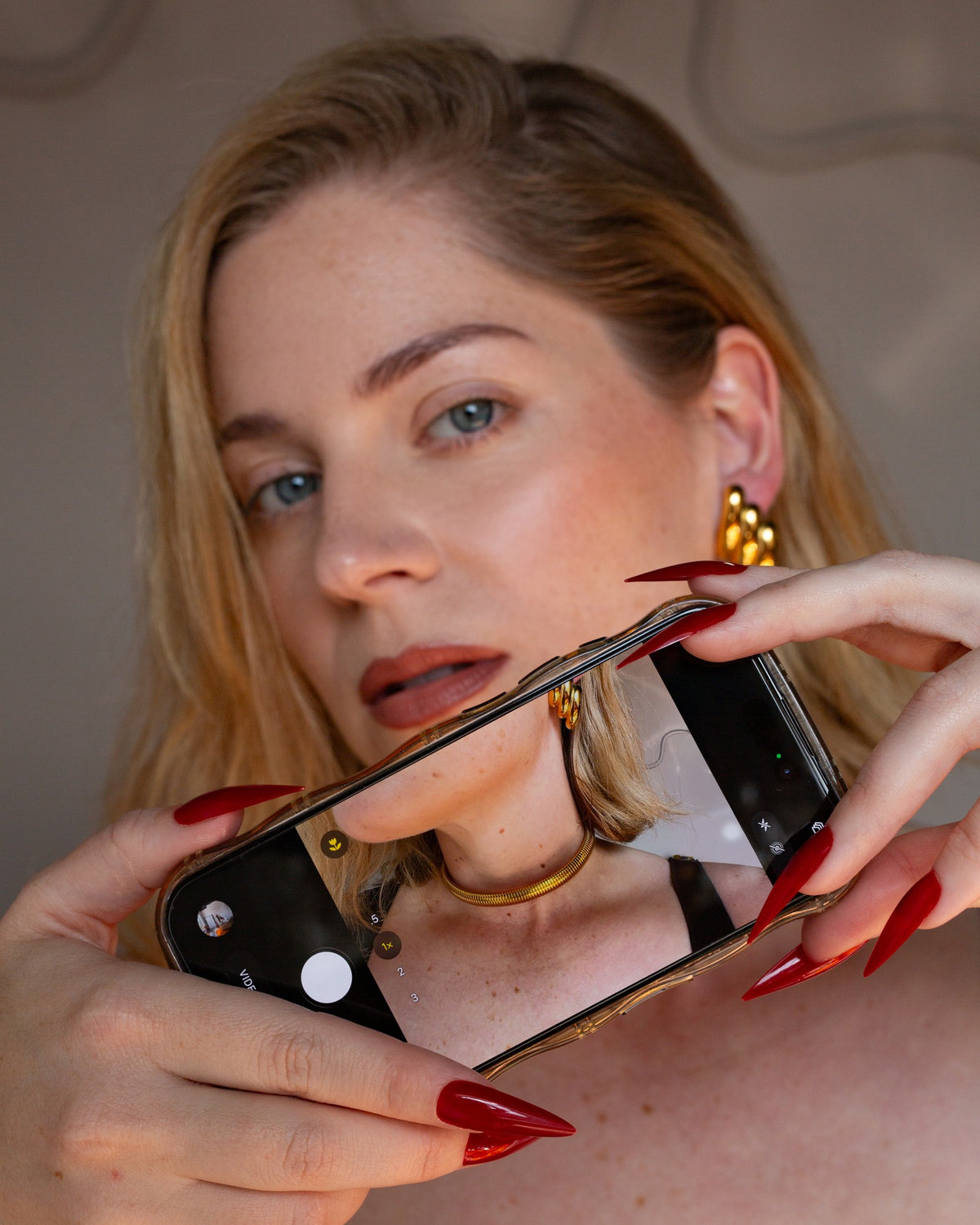 Blanc triple-ridge earrings styled in a close portrait with red nails.
