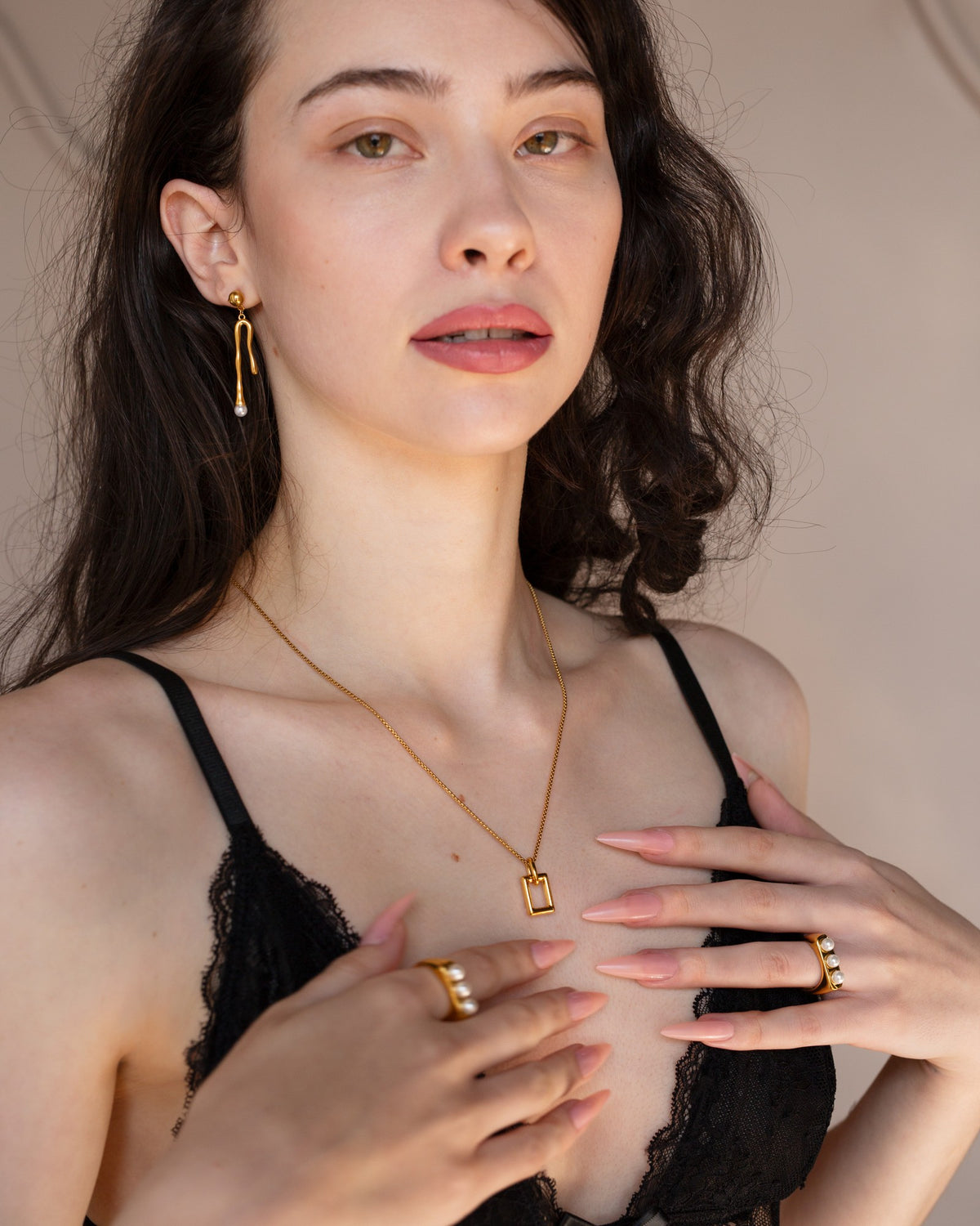 Cilla gold three-pearl ring worn with mixed rings in a front-facing portrait.