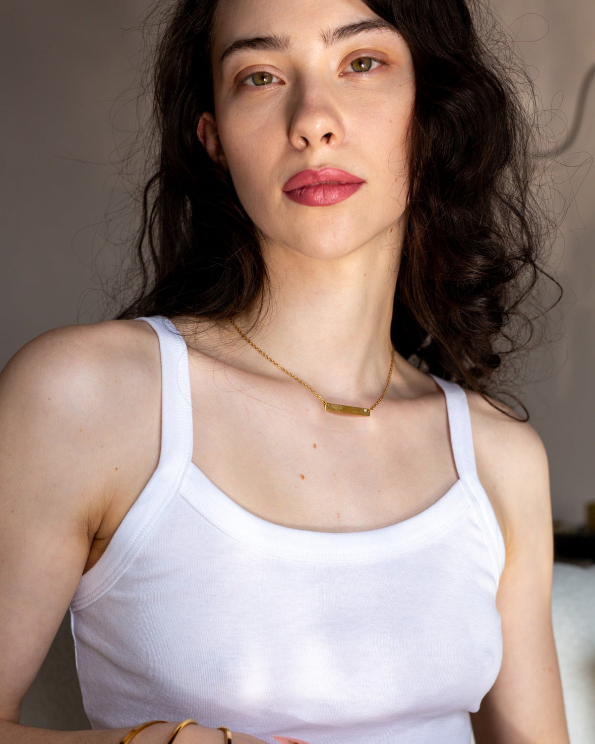 Close-up of a model wearing the gold Fuck Bar Necklace with a white tank.