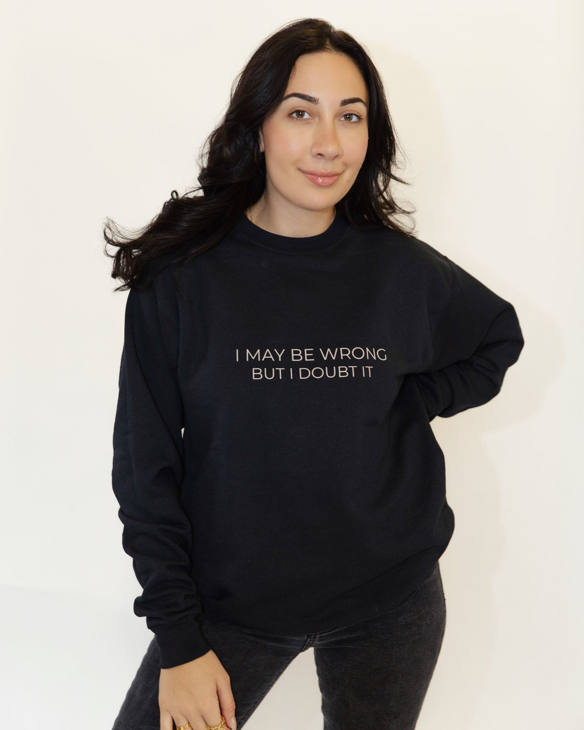 Woman wearing the black I May Be Wrong But I Doubt It crewneck sweatshirt.