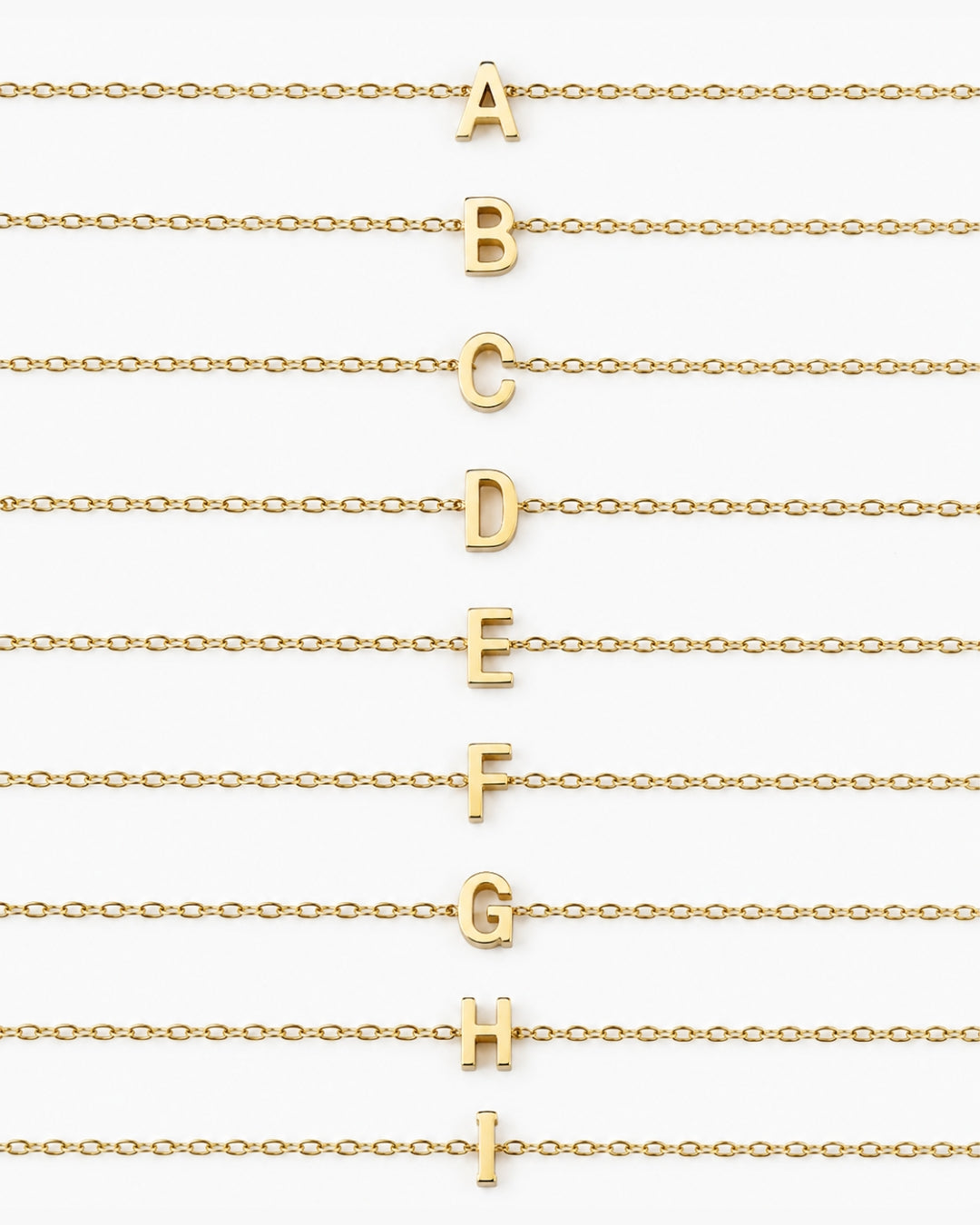 Initial Necklace letters A through I arranged on gold chains on a white background.