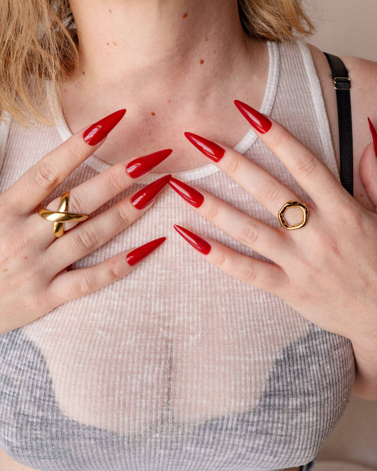 O Ring styled on a model with long red nails and mixed sculptural gold rings.
