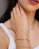 Penelope Bracelet, an 18K Gold PVD box chain bracelet worn in a close portrait.