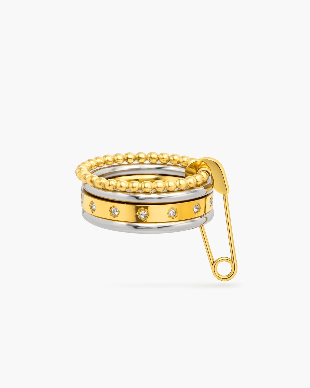 Piper mixed-metal stacked ring with beaded gold bands, clear stones and a safety-pin accent on a white background.