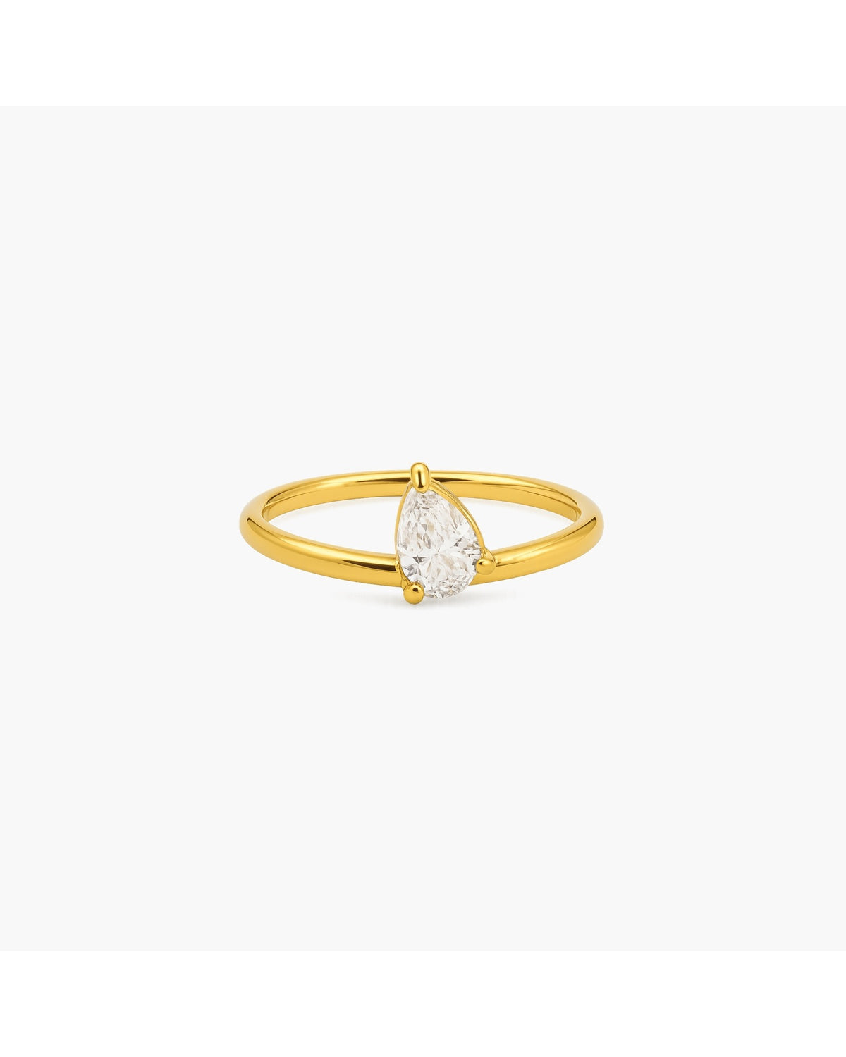 Gold-tone Rene split-band ring with a vertically set pear-shaped clear stone on a white background.