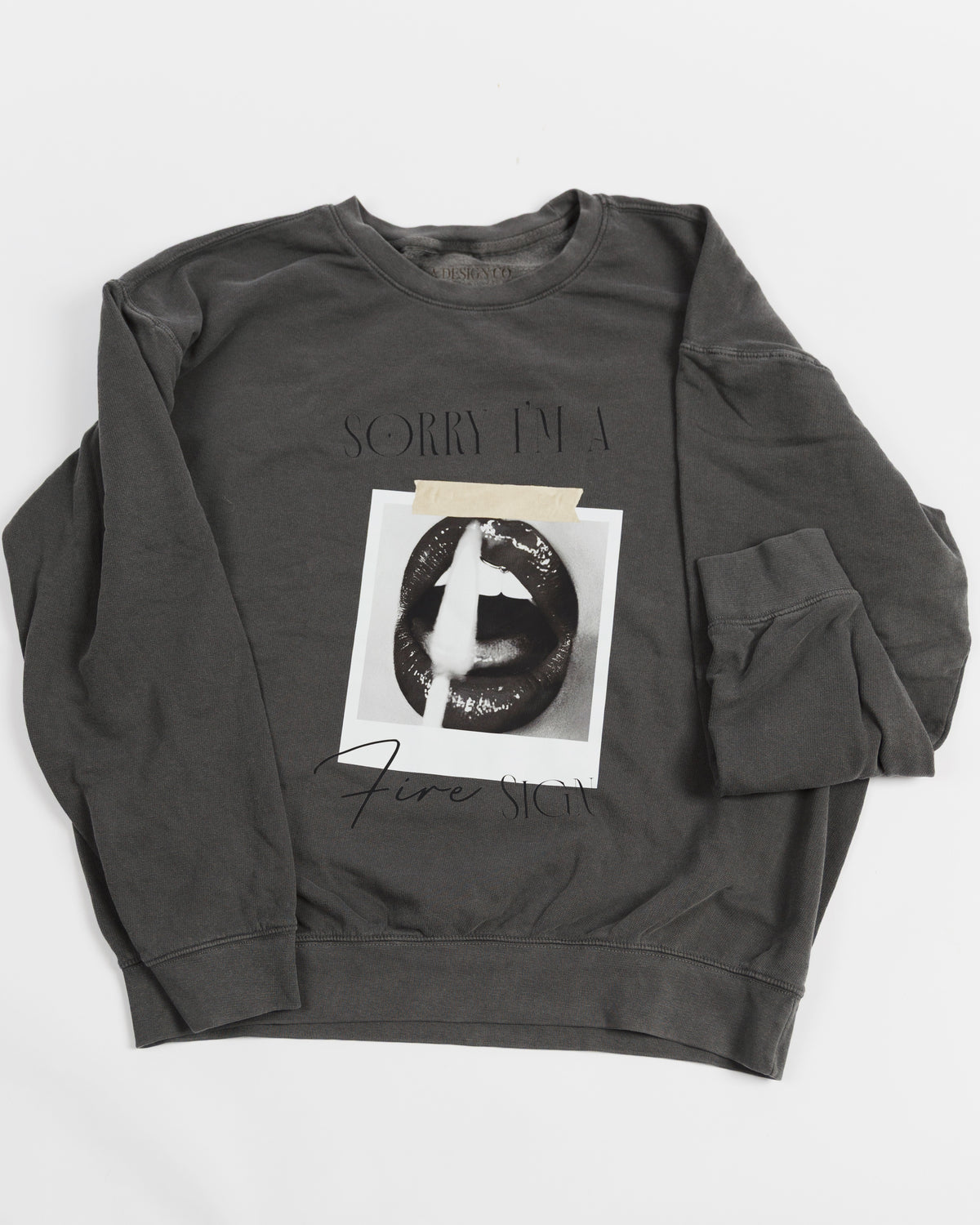 Washed charcoal Sorry I’m a Fire Sign crewneck sweatshirt laid flat.