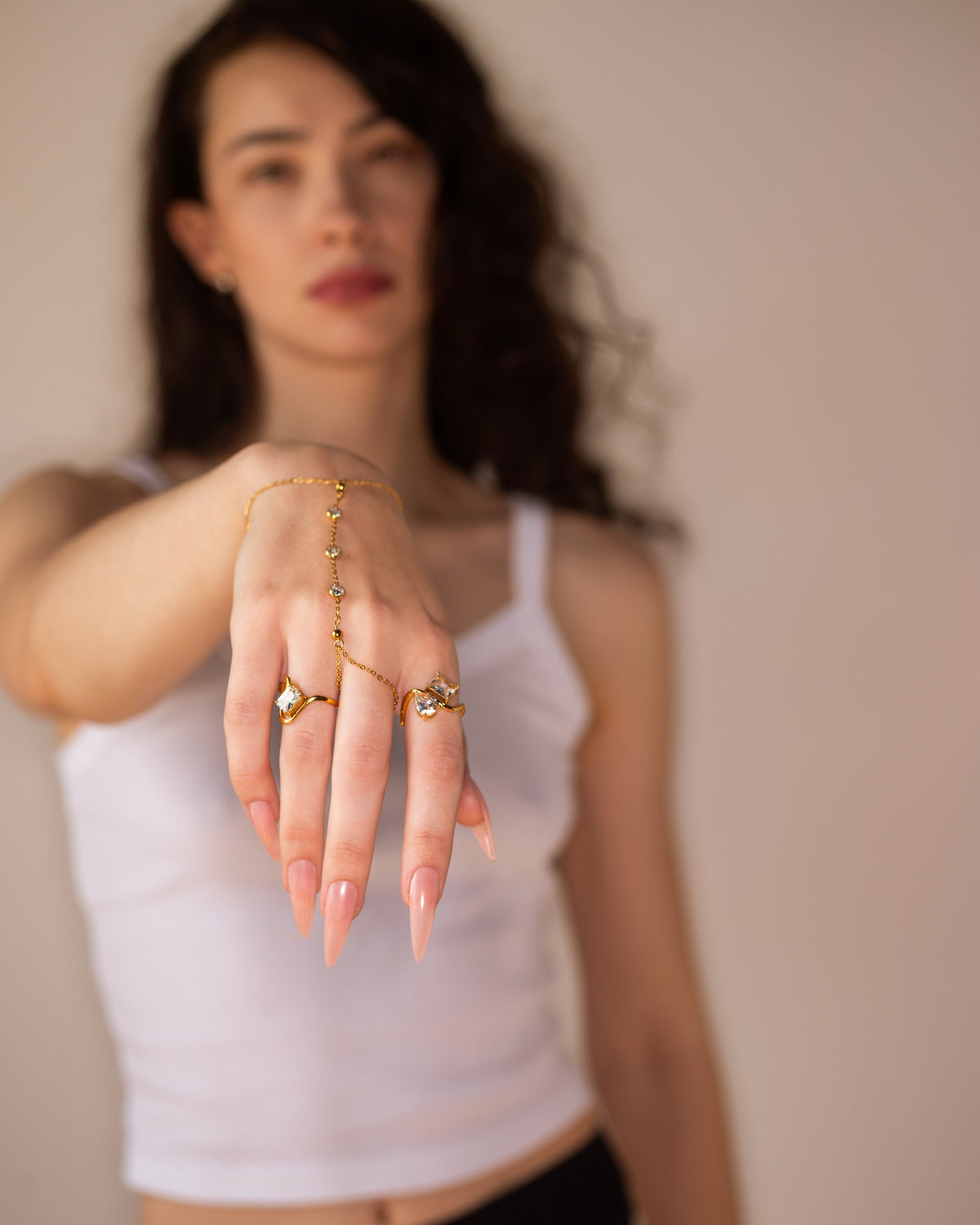 Talia asymmetrical two-stone ring displayed on an outstretched hand in a full fashion portrait.
