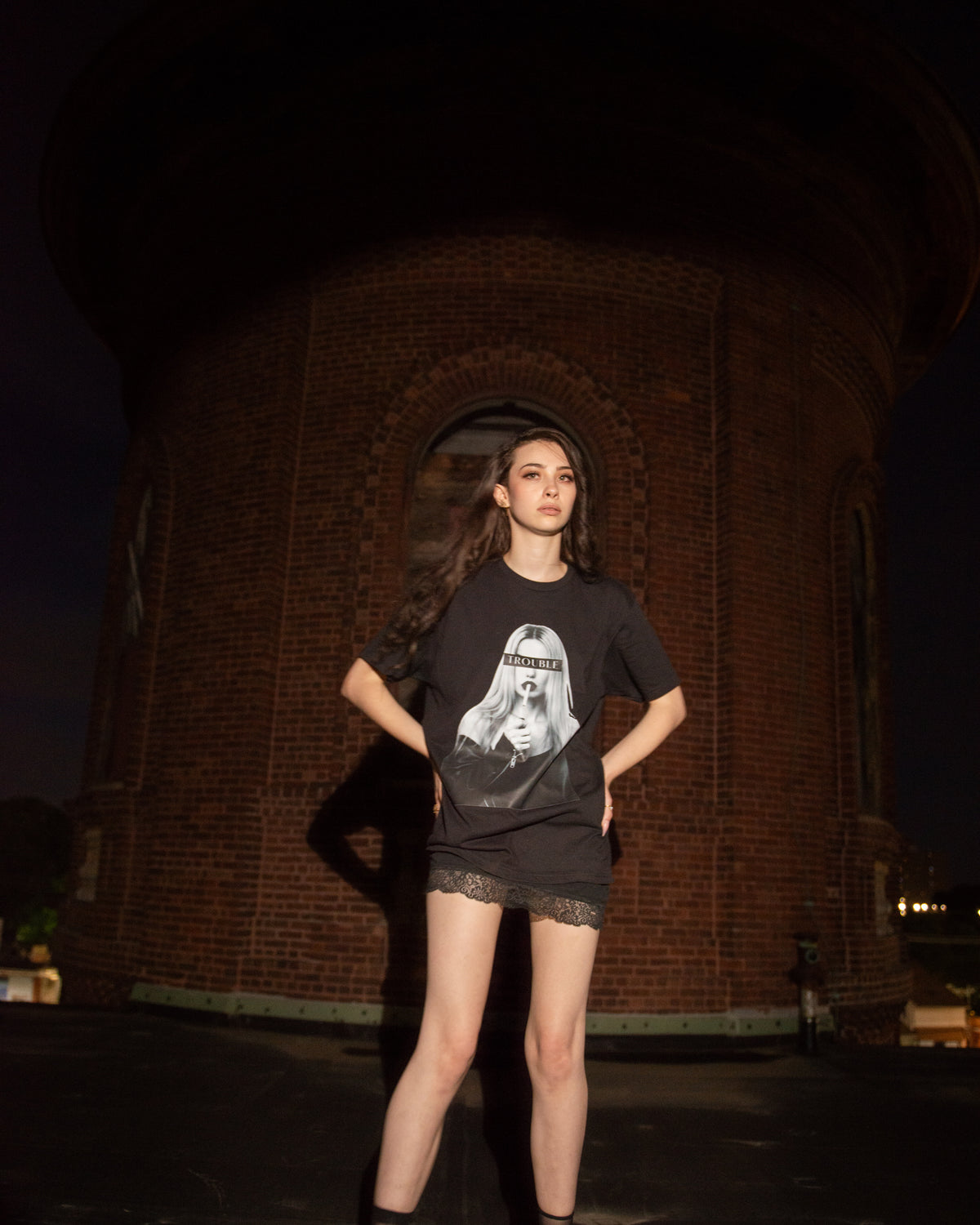 Lifestyle view of the black TROUBLE graphic T-shirt.
