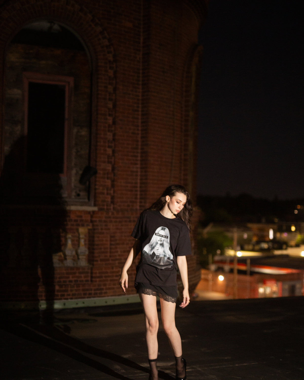 Additional nighttime lifestyle view of the black TROUBLE graphic T-shirt.