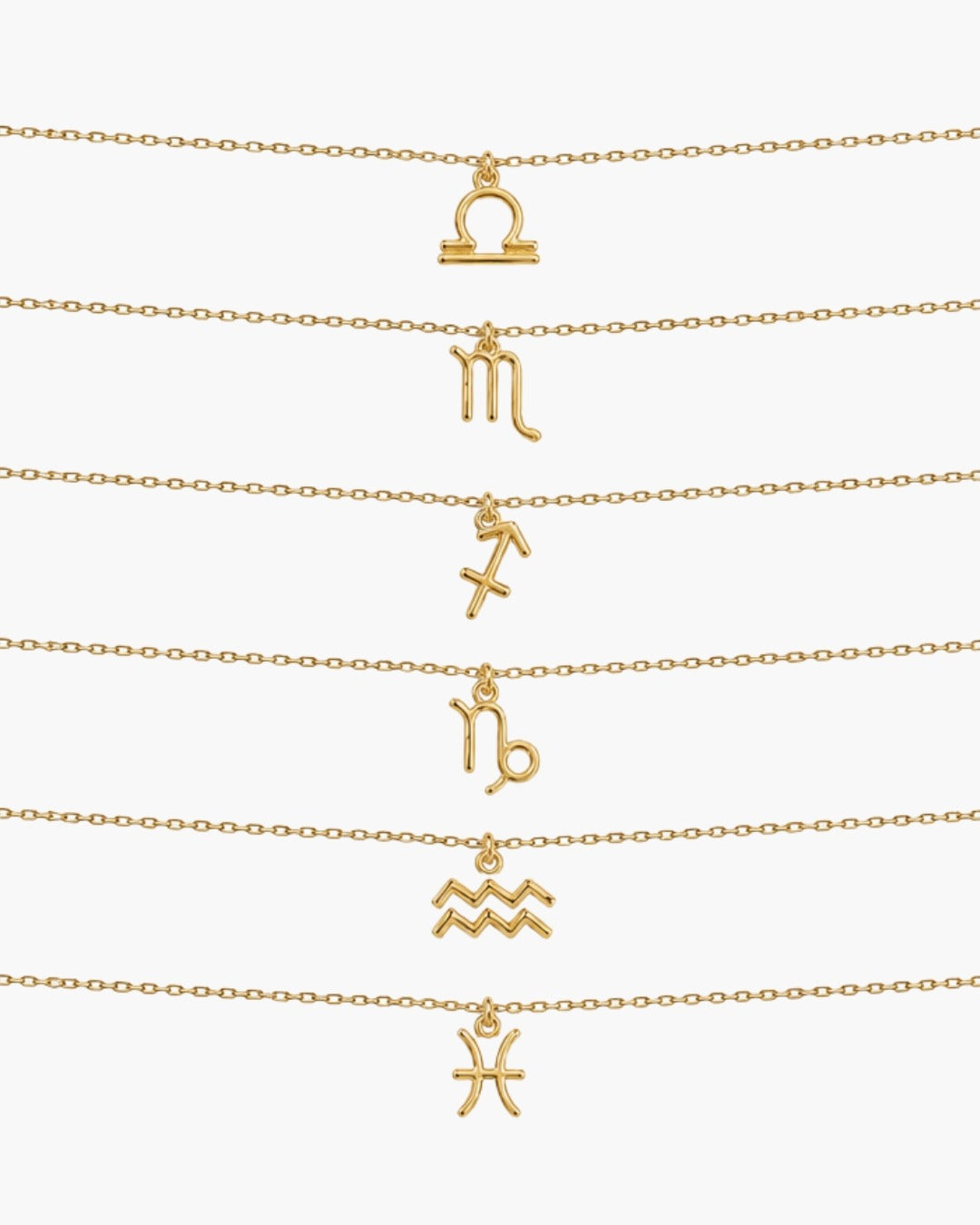 Gold zodiac necklaces for Libra through Pisces arranged on a white background.