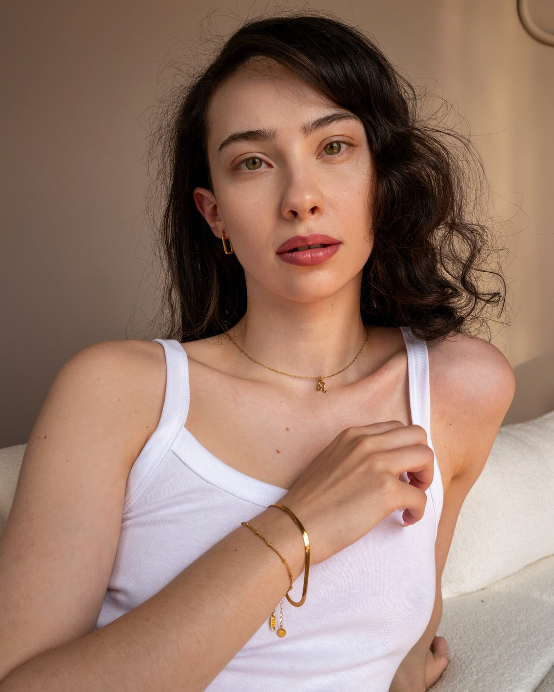Gold zodiac necklace worn in a styled lifestyle portrait.